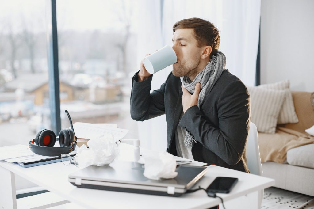 Young man ill with flu in office